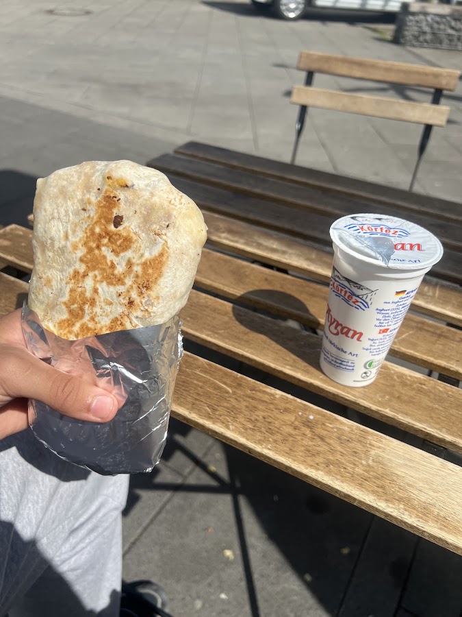 Dürüm-Rolle mit Becher Ayran im Freien